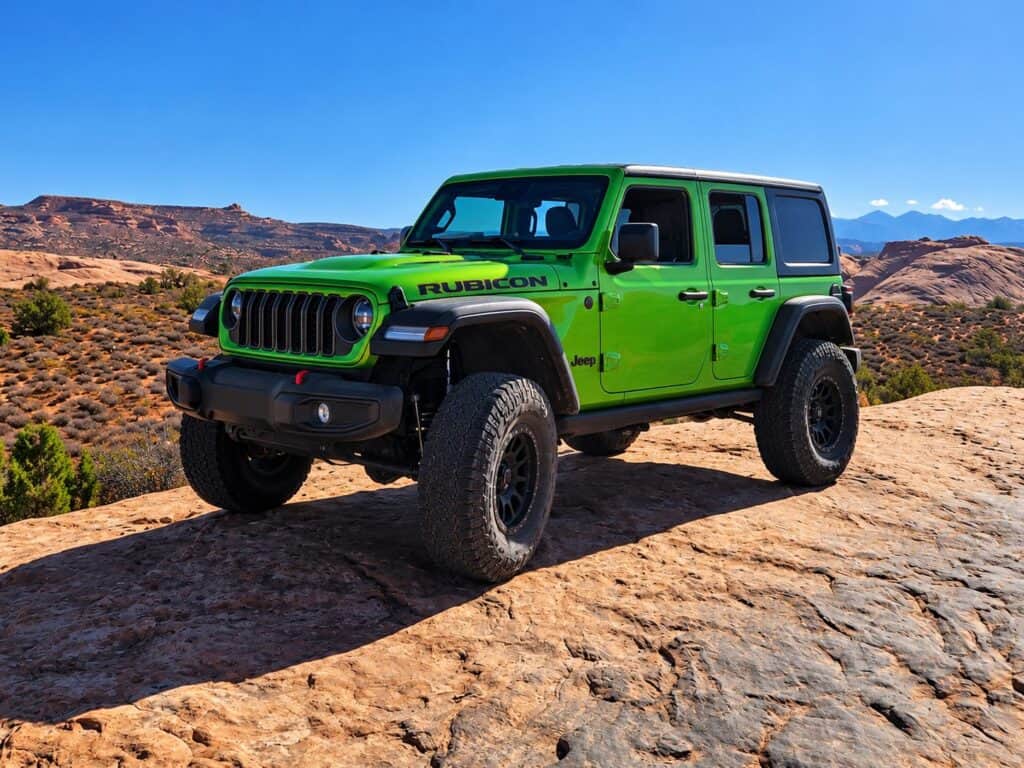 Renting a Jeep in Moab: pistachio-green Jeep Wrangler Rubicon rental on Moab slickrock