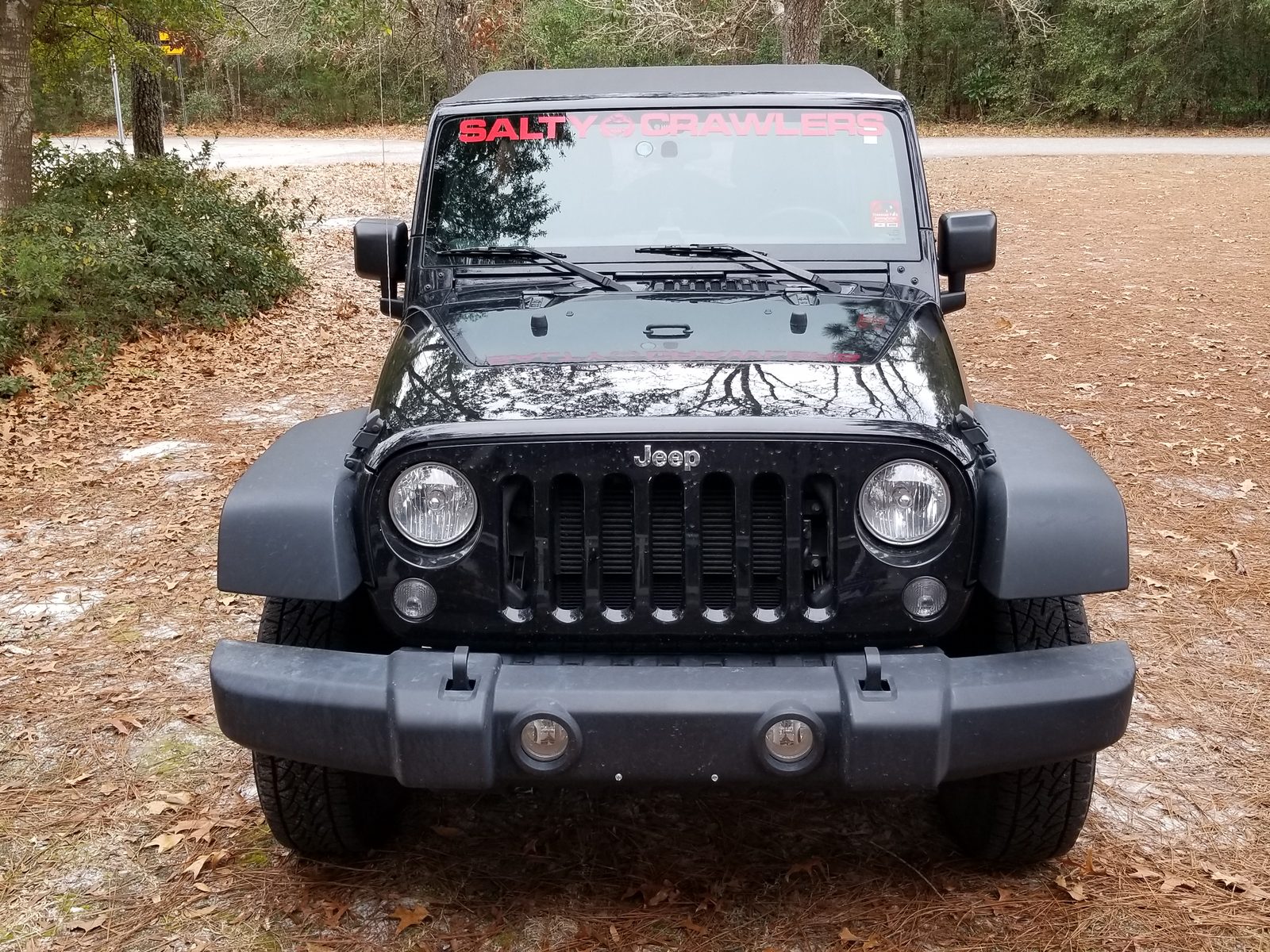 Stock black Jeep Wrangler Unlimited from the front with factory ride height, stock bumper, and factory tires